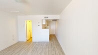 Located at 3040 N 35th Ave in Phoenix, Arizona, this compact single-floor unit offers a clean, functional layout designed to maximize its intimate footprint. The interior is finished throughout with light wood-style laminate flooring that lends warmth and continuity to the space.

The main living area is open and bright, featuring crisp white walls and a large window with vertical blinds that allows natural light to fill the room. A ceiling-mounted light fixture provides additional illumination, and the open layout offers flexibility for a variety of furniture arrangements. The living space flows directly into a kitchenette area equipped with a range, sink, and refrigerator, all finished in white cabinetry — a practical and efficient setup for everyday use.

The bathroom is accessed from the main living space and features a narrow, well-organized layout with wood-style flooring, a white vanity with sink, a toilet, and a closet with bifold doors. The all-white walls keep the space feeling clean and bright. A ventilation fixture is installed in the ceiling for air circulation.

The unit's overall aesthetic is minimal and neutral, with a consistent white color palette across all rooms that contributes to an airy, uncluttered ambiance. This space is well-suited for a single occupant seeking a straightforward, move-in ready home in Phoenix.