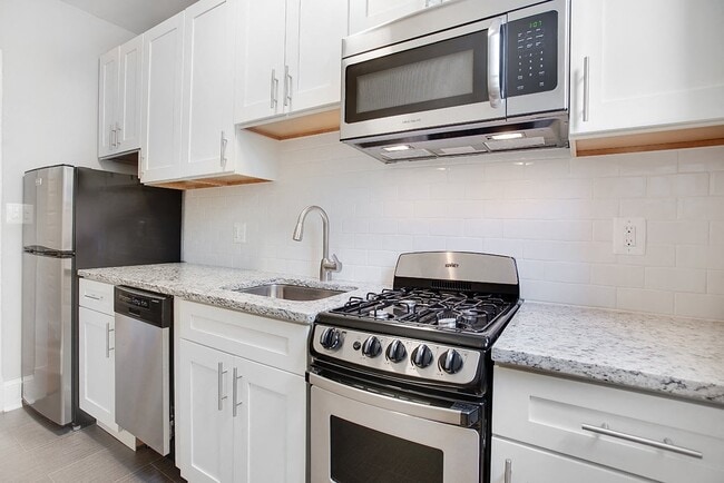 Renovated kitchen with granite countertops and stainless steel appliances - President Madison Apartments