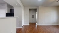 This single-story, one-bedroom, two-bathroom residence in Arlington, Texas, offers a thoughtfully arranged layout that maximizes every square foot of its living space. Rich hardwood-style flooring flows throughout the main living areas, lending a warm and cohesive aesthetic across the open-concept kitchen and living room. The kitchen is outfitted with dark espresso cabinetry, white quartz-style countertops, a classic subway tile backsplash, and black appliances including a range, refrigerator, and built-in microwave. A convenient pantry closet is tucked just off the kitchen, providing additional storage. The living room is bright and open, featuring a ceiling fan and large windows with blinds that allow natural light to fill the space, along with a glass door that opens to an outdoor area. The bedroom offers plush carpet flooring, a ceiling fan, and a window for natural light. Both bathrooms include hardwood-style flooring and neutral finishes consistent with the rest of the home. A dedicated in-unit laundry area with hookups adds everyday convenience. Neutral gray walls throughout create a clean, modern backdrop, making this Arlington residence a functional and inviting space.