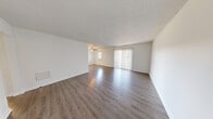 This 1-bedroom, 1-bathroom unit at 2215 Sumpter St in Hoover, Alabama offers a clean, modern interior across a single floor. The open living area is a standout feature, finished with rich hardwood-style flooring that reflects natural light pouring in through large vertical-blind-covered sliding glass doors. A ceiling fan anchors the space, contributing to both comfort and airflow. The neutral white walls and textured ceilings throughout lend a bright, cohesive aesthetic.

The kitchen is efficiently laid out with white cabinetry, granite-look countertops, a subway tile backsplash, a stainless steel sink, and white appliances including a range and dishwasher. Light wood-style flooring carries through this space seamlessly.

The bedroom is generously sized, featuring soft carpeting, a natural window for daylight, and access to a walk-in closet, providing ample storage. A second doorway connects conveniently to the rest of the unit.

The bathroom is well-appointed with a granite-topped vanity, a wide mirror, hardwood-style flooring, and a full-size soaking tub with a shower rod. The layout is practical and clean. Overall, the unit presents a well-maintained, move-in-ready living space in a convenient Hoover location.