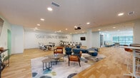 Oak Grove School is a thoughtfully designed educational facility located at 2200 Ingram Ave in Richmond, Virginia. The single-floor layout encompasses a generous footprint organized into eight distinct areas, each purpose-built to support learning, collaboration, and community engagement.

The main gathering area serves as the heart of the facility, featuring the prominent "Oak Grove School" wall signage, recessed lighting, and a mix of modern lounge seating — including tufted blue modular ottomans and leather accent chairs — alongside a large conference table equipped with a ceiling-mounted projector and wall-mounted display.

Adjacent spaces open into bright, airy corridors lined with floor-to-ceiling windows that flood the interior with natural light. A stylish lounge area offers a long upholstered bench, bar-height seating, and open views to the outdoors, creating an inviting atmosphere for informal gatherings.

The facility also includes a fully equipped kitchenette with stainless steel appliances, gray cabinetry, a decorative teal tile backsplash, and a dining table — ideal for family or staff use. A dedicated children's area features whimsical nature-themed murals, a sculptural tree centerpiece, bean bag seating, and curated bookshelves, fostering imaginative play and early learning. Private meeting rooms with glass-panel doors provide quieter settings for focused sessions. Light hardwood flooring and soft mint-green walls unify the space with a calm, welcoming aesthetic throughout.