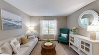 Located along the scenic SR-A1A corridor in Jacksonville, FL, this thoughtfully designed 2-bedroom, 2-bathroom residence offers a comfortable, single-floor layout with a warm coastal aesthetic throughout. The open-concept living and dining area welcomes you upon entry, featuring wood-look flooring, neutral taupe walls, and natural light streaming through large windows framed with sheer white curtains. The living room provides a relaxed yet polished atmosphere, accented by beach-inspired artwork and a jute area rug that ties the coastal theme together. The adjacent dining area offers an intimate setting with direct access to the front entry. The kitchen is equipped with stainless steel appliances, crisp white cabinetry, a teal tile backsplash, and ample counter space, combining functionality with style. Both bedrooms are carpeted and feature textured ceilings, soft neutral tones, and windows that invite natural light. The primary bedroom offers a serene retreat with tasteful coastal décor. Each bathroom includes a combination tub and shower, wood-look flooring, and a vanity with a light quartz-style countertop. A dedicated in-unit laundry room with wire shelving adds everyday convenience, while a hallway closet provides additional storage throughout this well-appointed home.