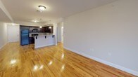 This well-appointed 2-bedroom, 1-bathroom residence at 75 Lackawanna Ave in Totowa, NJ offers a thoughtfully designed single-floor layout with a clean, modern aesthetic. Polished hardwood flooring runs throughout the entire unit, lending warmth and continuity to every room.

The open-concept living and dining area is bright and spacious, with neutral-toned walls that complement the natural light streaming in through large, blinds-fitted windows. The space flows seamlessly into the kitchen, which features rich dark espresso cabinetry, granite countertops, a stone tile backsplash, black appliances including a gas range, microwave, refrigerator, and dishwasher, along with a breakfast bar with pendant lighting — ideal for casual dining or entertaining.

Both bedrooms are generously sized, each with gleaming hardwood floors and windows offering pleasant outdoor views. The primary bedroom includes access to a dedicated walk-in closet. The full bathroom is finished with light tile flooring, a granite-topped white vanity, and a tub/shower combination with sliding glass doors, creating a clean and functional space. Throughout the unit, white panel doors and crisp baseboards add a polished, cohesive finish.