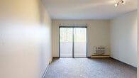 Located at 1510 Lakeview Dr in Darien, IL, this single-floor unit offers a straightforward, functional layout designed for comfortable everyday living. The floor plan, as revealed by the 3D scan, includes a spacious living area, a separate kitchen, at least one bedroom, and a bathroom.

The living area is generously proportioned, finished with neutral-toned carpet and cream-colored walls that create a bright, open atmosphere. A large sliding glass door fitted with vertical blinds serves as a prominent feature, flooding the space with natural light and providing views of mature trees and greenery outside. A wall-mounted air conditioning unit and baseboard heating are also present, offering year-round climate control.

The kitchen follows a galley-style configuration, featuring warm wood cabinetry on both sides, light countertops, a double-basin sink, and white appliances including a refrigerator, electric range, and dishwasher. The kitchen is finished with light hardwood-style flooring and includes a ceiling fan overhead.

The bedroom is carpeted and features neutral walls, with access through a wood-trimmed doorway. The bathroom includes a full-size tub and shower combo with a clean, all-white surround. Throughout the unit, the overall aesthetic is clean and understated, offering a practical and livable environment.