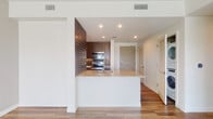 Located at 237 S Dixie Hwy in the heart of Coral Gables, Florida, this single-floor residence offers a thoughtfully designed open layout with a clean, contemporary aesthetic throughout. Warm hardwood-style flooring flows seamlessly across the living areas, complementing the bright, neutral color palette and crisp white walls.

The kitchen serves as a functional centerpiece, featuring rich dark wood cabinetry with sleek hardware, granite countertops, a peninsula with an undermount sink, and a full suite of stainless steel appliances including a range, microwave, refrigerator with ice maker, and dishwasher. A textured tile backsplash adds visual depth behind the cooking area.

The open living space benefits from generous natural light streaming through large sliding glass doors that lead to a private balcony, offering panoramic views of the surrounding Coral Gables landscape. A ceiling fan keeps the space comfortable and well-ventilated.

The bedroom is bright and airy, with a large window framing expansive sky and cityscape views. The bathroom is appointed with granite countertops, an undermount sink, warm wood-toned cabinetry, a large mirror with integrated lighting, and a walk-in shower with neutral tile surround.

The entry foyer features a paneled front door and louvered closet, providing a welcoming and practical arrival experience.