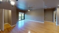 Located at 777 Commercial St SE in Salem, Oregon, unit 311 is a single-floor residence offering a well-organized and functional layout. The living area is generously proportioned, featuring light hardwood flooring, a ceiling fan, and a sliding glass door that opens to a private balcony with views of surrounding greenery, allowing natural light to fill the space.

The kitchen is a standout feature, equipped with rich cherry wood cabinetry, tile backsplash, a center island with a light countertop, and black appliances including a refrigerator with ice maker, electric range, microwave, and dishwasher. Recessed lighting illuminates the workspace efficiently. An adjacent walk-in pantry provides additional storage.

The hallway connects the living spaces to the bedrooms, one of which offers large windows with tree-lined views and plush carpeting. A dedicated closet area with built-in shelving and a wood cabinet base adds practical storage near the entry corridor.

The bathrooms feature travertine-style tile flooring and warm-toned walls. One bathroom includes a soaking tub and shower combination, while another features a rich vanity with stone countertop. A stacked washer and dryer unit is conveniently housed within the bathroom area, adding in-unit laundry functionality.