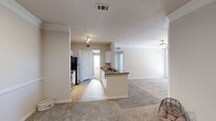 Located at 6111 N Beach St in Fort Worth, TX, this well-appointed apartment offers three bedrooms, two bathrooms, and a thoughtfully designed single-floor layout. The open-concept living and kitchen area forms the heart of the home, where light-toned carpet flows through the living room beneath a ceiling fan, creating a comfortable, airy atmosphere. The galley-style kitchen is outfitted with white cabinetry, dark granite-style countertops, stainless steel appliances including a range, microwave, and refrigerator, and wood-look flooring that adds warmth and easy maintenance. A peninsula with a sink and additional counter space connects the kitchen to the living area, enhancing functionality. The bedrooms are carpeted and filled with natural light from sizable windows dressed with blinds. The primary bedroom features a distinctive tray ceiling with a ceiling fan, adding an architectural touch. Closets include wire shelving systems for organized storage. The bathrooms are finished with wood-look flooring, white vanity cabinetry, and dark countertops. A dedicated laundry room with washer/dryer hookups adds everyday convenience. The neutral color palette throughout gives the space a clean, move-in-ready appeal.
