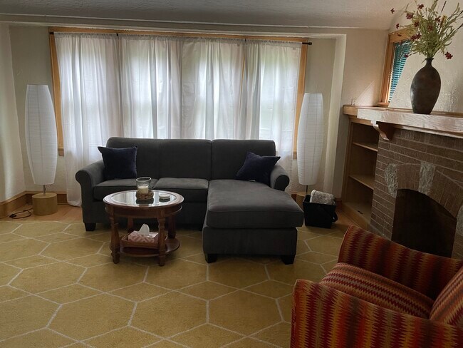 Spacious living room with faux fireplace, built in bookcases and mantle - 2809 S Lenox St