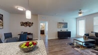 This single-floor residence offers a thoughtfully designed open-concept layout that seamlessly connects the kitchen, dining, and living areas. The kitchen is a standout feature, showcasing rich dark wood cabinetry, granite countertops, a subway tile backsplash, stainless steel appliances including a refrigerator, range, and built-in microwave, and a deep undermount sink — all illuminated by stylish pendant lighting. The open living area is bright and welcoming, with large windows allowing generous natural light, wood-style flooring, and a ceiling fan overhead.

The bedrooms are comfortably sized, each featuring wood-style flooring, large windows with blinds, and ceiling fans. The primary bedroom is served by an en-suite bathroom equipped with a granite-topped dark wood vanity and a shower-tub combination. A second full bathroom mirrors the quality finishes and includes a glass-enclosed walk-in shower. A dedicated in-unit laundry room with a full-size washer and dryer adds everyday convenience. Neutral tones, clean lines, and consistent wood-style flooring throughout give the space a cohesive, modern aesthetic that is both functional and inviting.