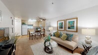 Located at 5601 Natomas Blvd in Sacramento, CA, this efficiently designed one-bedroom, one-bathroom residence makes excellent use of its single-floor layout. The open-concept living and dining area serves as the heart of the home, featuring light-toned flooring, a ceiling fan, and large windows fitted with blinds that allow natural light to fill the space. The living area offers a comfortable and welcoming ambiance, flowing seamlessly into a dedicated dining space. The kitchen is equipped with light wood cabinetry, laminate countertops, white appliances including a range, built-in microwave, dishwasher, and refrigerator, all set over durable hardwood-style flooring. The spacious bedroom includes a ceiling fan, a generous closet, and a window with blinds and warm drapery that lends a cozy atmosphere. The full bathroom features a tub-shower combination, a vanity with storage, and hardwood-style flooring. Additional practical amenities include a dedicated laundry area and hallway with closet storage. The overall design is clean and bright, with white walls and neutral finishes throughout that create a calm, functional living environment.