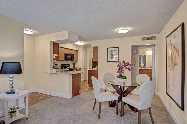 A living room with a view into the kitchen and overhead lighting - Motif