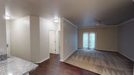 This single-story residence offers a well-organized layout that balances open communal spaces with defined private areas. The living room is carpeted and benefits from natural light streaming through sliding glass doors that lead to an outdoor area, complemented by a ceiling fan overhead and crown molding that adds a refined architectural detail. Adjacent to the living space, the dining area features rich hardwood-style flooring, chair rail molding, and a pendant light fixture, creating a clean transition to the kitchen.

The kitchen is equipped with stainless steel appliances, including a refrigerator, range, and microwave, alongside warm-toned cabinetry, granite countertops, a stainless steel sink, and track lighting overhead. A dedicated in-unit laundry area accommodates a full-size washer and dryer with overhead wire shelving for added storage.

The two bedrooms are carpeted and receive natural light through windows with blinds. Each room offers generous proportions, with one bedroom featuring an arched ceiling detail and another providing a closet with built-in shelving. Both bathrooms include hardwood-style flooring, vanities with granite or solid-surface countertops, and a tub-shower combination.