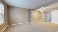 Located at 2287 Pinnacle Ct in Erie, PA, this 2-bedroom, 2-bathroom home spans three floors, offering a well-organized layout with dedicated spaces for living, dining, and utility needs. The ground floor houses an attached garage with a full automatic door and a utility room. The main living level features two distinct living areas, both finished with neutral-toned carpet and warm beige walls. A ceiling fan with integrated lighting adds comfort to the open living space. The kitchen is well-appointed with rich, dark wood cabinetry, white countertops, stainless steel appliances including a range, microwave, and dishwasher, and light hardwood-style flooring. A bright window on this floor fills the entry area with natural light. The upper floor is home to two carpeted bedrooms, including a spacious primary bedroom featuring a large closet with bi-fold doors and access to an adjacent room. Both bathrooms are clean and functional, one featuring a white vanity with a framed mirror and brushed nickel fixtures. Throughout, the home maintains a consistent neutral color palette of warm beige and gray tones, creating a cohesive and move-in ready atmosphere.