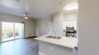 Located in Colorado Springs, CO, this well-designed one-bedroom, one-bathroom unit offers a functional and modern living experience on a single floor. The open-concept layout seamlessly connects the kitchen and living room, creating an inviting and efficient use of space throughout.

The kitchen is equipped with stainless steel appliances, including a gas range, microwave, and refrigerator, complemented by white cabinetry and a peninsula island featuring a double stainless steel sink with a brushed nickel faucet and light quartz countertops. The living area benefits from a ceiling fan and sliding glass doors that lead to a private balcony, offering scenic mountain views — a standout feature of this Colorado Springs location.

The bedroom is a comfortable size, featuring hardwood-style flooring, a ceiling fan, a large window that invites natural light, and access to a dedicated closet. The bathroom is thoughtfully equipped with accessibility-friendly grab bars throughout, a combination tub and shower with tiled surround, and durable wood-look flooring.

Consistent hardwood-style flooring flows throughout the unit, paired with neutral gray walls and clean white trim, creating a bright, cohesive, and modern aesthetic. The space is practical, accessible, and well-suited for comfortable everyday living.