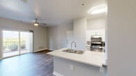 Located in Colorado Springs, CO, this well-designed one-bedroom, one-bathroom unit offers a functional and modern living experience on a single floor. The open-concept layout seamlessly connects the kitchen and living room, creating an inviting and efficient use of space throughout.

The kitchen is equipped with stainless steel appliances, including a gas range, microwave, and refrigerator, complemented by white cabinetry and a peninsula island featuring a double stainless steel sink with a brushed nickel faucet and light quartz countertops. The living area benefits from a ceiling fan and sliding glass doors that lead to a private balcony, offering scenic mountain views — a standout feature of this Colorado Springs location.

The bedroom is a comfortable size, featuring hardwood-style flooring, a ceiling fan, a large window that invites natural light, and access to a dedicated closet. The bathroom is thoughtfully equipped with accessibility-friendly grab bars throughout, a combination tub and shower with tiled surround, and durable wood-look flooring.

Consistent hardwood-style flooring flows throughout the unit, paired with neutral gray walls and clean white trim, creating a bright, cohesive, and modern aesthetic. The space is practical, accessible, and well-suited for comfortable everyday living.