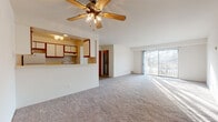 This single-floor residence offers two bedrooms and two full bathrooms within a thoughtfully arranged floor plan. The open-concept living and dining area is generously sized, featuring plush wall-to-wall carpeting, a ceiling fan with light fixture, and a sliding glass door that fills the space with natural light while providing outdoor views. The front entry flows seamlessly into the living area, with a dedicated closet nearby for added convenience.

The galley-style kitchen is efficiently designed, featuring white cabinetry with wood trim accents, light countertops, a stainless steel sink, and white appliances including a refrigerator, range, and dishwasher. A pass-through counter connects the kitchen to the living area, enhancing the open feel. The kitchen is finished with wood-look flooring for easy maintenance.

Both bedrooms are carpeted and receive natural light through sliding or standard windows with outdoor views of surrounding greenery. One bedroom features dual closets, offering ample storage. Each bathroom is finished with wood-look flooring, a vanity with a wide mirror, and clean white fixtures. The overall aesthetic is neutral and move-in ready, with a practical layout suitable for a variety of living arrangements.