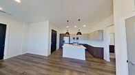 This contemporary 600 square foot apartment offers a thoughtfully designed living space. The open-concept layout seamlessly integrates the kitchen, living, and dining areas, creating a sense of spaciousness. The kitchen is a highlight, boasting modern cabinetry, stainless steel appliances, and a large island with a sink, perfect for meal preparation and casual dining.

The living area is bathed in natural light, thanks to multiple large windows with horizontal blinds. These windows not only brighten the space but also offer views of the surrounding area. The bedroom, measuring 140 square feet, provides a cozy retreat with ample room for a bed and additional furniture.

Throughout the apartment, you'll find high-quality finishes, including durable wood-look flooring and recessed lighting. The bathroom features a modern vanity with a backlit mirror, a sleek toilet, and a shower-tub combination with stylish tiling.

Additional amenities include a closet for storage and a hallway connecting the various spaces. The apartment's neutral color palette and clean lines create a contemporary aesthetic that serves as a perfect canvas for personal decoration. This efficient one-floor layout maximizes every square foot, offering comfortable living in a compact urban setting.