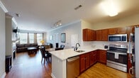 Located at 311 Lowell St in Andover, Massachusetts, this single-floor residence offers a thoughtfully designed open-concept layout that seamlessly connects the kitchen, dining, and living areas. The kitchen is a standout feature, showcasing rich warm-toned cabinetry, white quartz countertops, a peninsula with an undermount sink and stainless steel dishwasher, and a full suite of stainless steel appliances including a range, over-the-range microwave, and French door refrigerator. Crown molding and track lighting add a polished touch to the main living space, which is anchored by hardwood floors and large windows that invite natural light. The living room provides a comfortable, open atmosphere with dual windows offering outdoor views. Two well-sized bedrooms feature plush carpeting, multiple windows, and ample natural light. The primary bedroom includes generous storage with a dresser area and an en-suite bath. The bathroom is finished with warm wood vanity cabinetry, a white quartz countertop, a large mirror, and a tiled tub-shower combination. Throughout the residence, neutral wall tones, clean lines, and quality finishes create a cohesive and inviting ambiance.