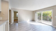 Located at 6404 NW 70th St in Kansas City, MO, this single-floor, 2-bedroom, 3-bathroom home offers a well-organized layout designed for comfortable everyday living. The bright living room is a standout feature, with light wood-style flooring, neutral warm-toned walls, and a large sliding glass door that opens to a private outdoor deck, flooding the space with natural light and providing pleasant views of surrounding greenery. Adjacent to the living room, the dining area flows seamlessly into the galley-style kitchen, which is outfitted with gray cabinetry, stainless steel appliances including a refrigerator and range, and light flooring. Louvered closet doors add a functional, classic touch. Both bedrooms are carpeted and bathed in natural light from well-placed windows. The spacious primary bedroom includes an en-suite bathroom, providing added privacy and convenience. The three bathrooms are finished with light wood-style flooring and clean white tiling, including a tub-shower combination. Additional spaces include a utility room, hallway, and multiple closets offering practical storage throughout. Textured ceilings are consistent across the home, contributing to its cohesive, well-maintained character.