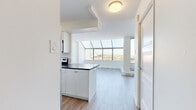 Located on the 10th floor at 5600 Sheppard Avenue East in Toronto's Scarborough community, this well-appointed one-bedroom, one-bathroom unit offers a bright and functional layout with thoughtful finishes throughout. Light hardwood flooring flows seamlessly across the entire unit, creating a clean, cohesive aesthetic.

The living area is a standout feature, boasting dramatic floor-to-ceiling windows and a skylight-style glazed ceiling panel that floods the space with natural light while framing sweeping city and treetop views. A separate balcony access adds to the open, airy feel of the living space.

The kitchen is efficiently designed with white cabinetry, dark countertops, a subway tile backsplash, and a full suite of stainless steel appliances including a refrigerator, dishwasher, and range. A window above the sink brings in additional natural light.

The bedroom is a comfortable, well-proportioned retreat with its own window offering city views, baseboard heating, and a sliding mirrored closet that enhances both storage and the sense of space.

The bathroom is finished with large-format stone-look floor tiles, classic white subway tile surrounding the soaking tub and shower, a sleek white vanity with an integrated sink, and chrome fixtures, delivering a clean and timeless look throughout.