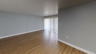 Located at 3506 Silver Park Drive in Suitland, Maryland, this single-floor residence offers a well-designed layout with modern finishes throughout. The open living area features warm hardwood-style flooring and a large sliding glass door fitted with vertical blinds, allowing generous natural light to fill the space and providing direct access to a screened balcony. The balcony, finished with wood decking and a wood-beam ceiling, overlooks a community pool surrounded by mature trees, offering a pleasant outdoor retreat.

The kitchen is equipped with white shaker-style cabinetry, granite-look countertops, and a black refrigerator, all set against the same hardwood-style flooring that runs throughout the main living areas. A hallway with wood-look flooring connects the living spaces to the private quarters, where the bedrooms feature plush carpeting, natural window light, and ample closet space — including a bedroom with dual closets.

The bathroom is tastefully updated with marble-style tile flooring, a dark-finished vanity with granite countertops, and a well-lit mirror, creating a clean and refined aesthetic. Textured ceilings and neutral gray walls are consistent throughout, contributing to a cohesive and move-in ready atmosphere.