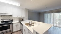 Located at 4580 Barclay Dr in Dunwoody, GA, this one-bedroom, one-bathroom residence offers a well-designed layout across a single floor. The updated kitchen is a standout feature, showcasing white shaker cabinetry, white quartz countertops, a subway tile backsplash, stainless steel appliances, and wood-look flooring — providing a clean, modern aesthetic. The combined kitchen and living area flows naturally, with the living room highlighted by crown molding, recessed lighting, and wide-plank hardwood-style flooring. Sliding glass doors flood the space with natural light and open directly onto a private balcony, which overlooks a lush, tree-lined backdrop for a serene outdoor retreat. The bedroom features soft carpeting, a generous window with views of the surrounding greenery, and access to a dedicated closet. The full bathroom is finished in a crisp, neutral palette with white cabinetry, a large vanity mirror, and wood-look flooring. Throughout the residence, a consistent neutral color scheme and thoughtful finishes create a cohesive, move-in-ready environment well-suited for comfortable everyday living in the heart of Dunwoody.