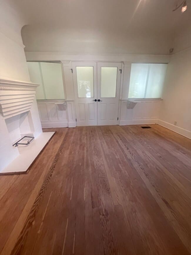 Living room with working fireplace. Restored hardwood floors before clear varnish application. - 1135 Magnolia St