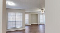 Located at 9939 Quail Blvd in Austin, TX, this two-bedroom, one-bathroom single-floor home offers a functional and comfortable layout. The living room serves as the heart of the space, featuring wood-look plank flooring, neutral-toned walls, a textured ceiling, and a ceiling fan with integrated lighting. Multiple windows dressed with horizontal blinds fill the area with natural light, while a dedicated entrance door provides convenient access. A pass-through opening connects the living area to the kitchen, which is equipped with built-in appliances including a microwave.

Both bedrooms are carpeted and finished with the same warm neutral palette, offering a cozy feel. The primary bedroom is a well-proportioned retreat that includes access to a dedicated walk-in closet with built-in shelving. The second bedroom features vertical blinds over a large window, providing ample light and privacy. The shared bathroom includes a shower/tub combination and a marble-look vanity countertop.

A dedicated laundry area with built-in shelving and washer/dryer hookups adds everyday convenience. The overall design is clean, practical, and move-in ready, making this Austin home an efficient and comfortable living space.