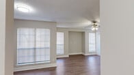 Located at 9939 Quail Blvd in Austin, TX, this two-bedroom, one-bathroom single-floor home offers a functional and comfortable layout. The living room serves as the heart of the space, featuring wood-look plank flooring, neutral-toned walls, a textured ceiling, and a ceiling fan with integrated lighting. Multiple windows dressed with horizontal blinds fill the area with natural light, while a dedicated entrance door provides convenient access. A pass-through opening connects the living area to the kitchen, which is equipped with built-in appliances including a microwave.

Both bedrooms are carpeted and finished with the same warm neutral palette, offering a cozy feel. The primary bedroom is a well-proportioned retreat that includes access to a dedicated walk-in closet with built-in shelving. The second bedroom features vertical blinds over a large window, providing ample light and privacy. The shared bathroom includes a shower/tub combination and a marble-look vanity countertop.

A dedicated laundry area with built-in shelving and washer/dryer hookups adds everyday convenience. The overall design is clean, practical, and move-in ready, making this Austin home an efficient and comfortable living space.