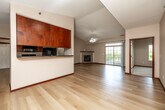 Located in Pleasant Hill, Iowa, this well-appointed 2-bedroom, 2-bathroom single-floor residence offers a thoughtfully designed layout with a seamless blend of comfort and functionality. The open-concept kitchen and living area serves as the heart of the home, featuring light hardwood-style flooring throughout, vaulted ceilings with a ceiling fan, and a gas fireplace that anchors the living space. Sliding glass doors lead to a private balcony with pleasant outdoor views, filling the room with natural light. The galley-style kitchen is equipped with rich warm-toned cabinetry, dark countertops, and a full suite of black appliances including a range, microwave, refrigerator, and dishwasher. The spacious primary bedroom includes soft carpeting, two windows overlooking lush greenery, and access to a generously sized walk-in closet with wire shelving. The second bedroom is equally well-lit with large windows and plush carpeting. Both bathrooms feature tile flooring, warm wood vanities, and clean white fixtures, with the primary bath offering a walk-in shower. A dedicated laundry room with full-size washer and dryer hookups adds everyday convenience, while two closets provide ample storage throughout the home.