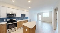 Located at 2500 SW 22nd Terrace in Fort Lauderdale, FL, this one-bedroom, one-bathroom residence offers a well-designed layout across a single floor. Neutral large-format tile flooring flows consistently throughout the space, lending a clean, cohesive aesthetic.

The kitchen is a standout feature, boasting a two-tone design with crisp white upper cabinetry and warm wood-toned lower cabinets, accented by a striking blue tile backsplash. A curved peninsula island with a light quartz countertop provides additional prep space and casual seating. Stainless steel appliances — including a French door refrigerator with ice maker, electric range, microwave, and dishwasher — complete the functional and stylish setup. Recessed lighting illuminates the space effectively.

The bedroom is a comfortable, well-proportioned room featuring a ceiling fan, natural light from a large window, and direct access to a spacious walk-in closet equipped with dual wire shelving systems for ample storage.

The bathroom offers a clean, modern design with a glass-enclosed walk-in shower adorned with large-format tile surround, and an additional storage closet within the room. Neutral tones and recessed lighting create a calm, functional atmosphere. A hallway connects the rooms efficiently, completing this thoughtfully laid-out Fort Lauderdale residence.