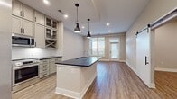 This efficiently designed 760 square foot space maximizes functionality within its single-floor layout. The interior showcases contemporary design elements, including smooth, neutral-toned walls and durable wood-look flooring that adds warmth and character to the rooms. A standout feature is the large window, which floods the space with natural light and provides a connection to the outdoors. The window is equipped with horizontal blinds for light control and privacy. Adjacent to the window, a glass door leads to what appears to be a balcony or outdoor area, enhancing the living experience with potential for fresh air and views. Recessed lighting in the ceiling ensures even illumination throughout the space. The room's clean lines and uncluttered appearance create a sense of openness, making the area feel spacious despite its compact footprint. With four distinct areas within this floor plan, the layout likely accommodates essential living spaces efficiently, potentially including a living area, bedroom, kitchen, and bathroom, though specific room designations are not visible in the image.