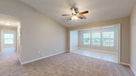 Located in Spanish Fort, Alabama, this single-story, 2-bedroom, 1-bathroom home offers a thoughtfully designed layout that maximizes comfort and functionality. The combined kitchen and living area forms the heart of the home, with vaulted ceilings adding a sense of openness and volume. The living room features plush carpeting and a ceiling fan, while an adjacent tiled dining area benefits from large windows that flood the space with natural light and offer views of surrounding greenery. The kitchen is well-equipped with white shaker-style cabinetry, granite-look countertops, a peninsula with additional counter space, black appliances including a range, microwave, and refrigerator, and durable light wood-look flooring. A hallway connects the main living areas to the private quarters. The spacious primary bedroom includes plush carpet, a ceiling fan, a large window, and access to a walk-in closet. The second bedroom also features carpet and a ceiling fan. The bathroom is outfitted with a dual-sink vanity topped with granite-look countertops, white cabinetry, and wood-look flooring. Two closets provide ample storage throughout the home, completing this clean and functional single-floor layout.
