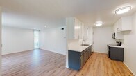 Located at 14960 Sherman Way in Van Nuys, CA, this thoughtfully renovated single-floor unit offers a clean, modern aesthetic with an open-concept design that seamlessly connects the kitchen and living area. Light wood laminate flooring runs consistently throughout, creating a warm, cohesive feel across every room.

The kitchen is well-appointed with a two-tone cabinet design — white upper cabinets paired with slate-gray lower cabinetry — complemented by white quartz countertops and a stainless steel double sink. A dishwasher and range are also present, along with ample pantry-style storage cabinetry. The kitchen opens directly into the spacious living area, which benefits from recessed lighting and a large sliding glass door fitted with vertical blinds that floods the space with natural light and provides outdoor access.

The bedrooms are bright and comfortable, each featuring recessed lighting, light wood flooring, and windows with vertical blinds. The hallway connects the living spaces to the private areas of the unit with clean, minimalist finishes throughout. The bathroom features a glass-enclosed walk-in shower, wood-tone flooring, a white vanity with dark cabinetry, and brushed nickel hardware and fixtures. The overall ambiance is fresh, light-filled, and move-in ready.