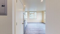 Located at 2801 S Hanford St, Unit B in Seattle's Beacon Hill neighborhood, this studio unit offers a thoughtfully designed single-floor layout that maximizes every square foot. The open main living area is finished with light gray wood-look luxury vinyl plank flooring that extends throughout, creating a cohesive and easy-to-maintain surface. Warm, neutral-toned walls and recessed lighting keep the space feeling bright and airy, while large windows allow natural light to fill the room and offer views of the surrounding neighborhood.

The kitchen is efficiently arranged along one wall and features white shaker-style cabinetry — both upper and lower — paired with dark countertops and a stainless steel backsplash. Stainless steel appliances include a full-size refrigerator, an electric cooktop with a range hood, and a microwave, along with a single-basin stainless steel sink.

The bathroom is clean and functional, finished with warm-toned tile flooring and white walls. It includes a wall-mounted sink with a brushed nickel faucet, a toilet, and grab bars, suggesting an accessible design. The compact layout is efficient and well-appointed. Overall, this unit presents a modern, move-in-ready space well-suited for those seeking a streamlined urban lifestyle in Seattle.
