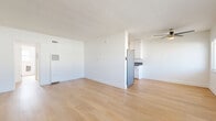 Located at 3910 Coco Ave in the Baldwin Hills neighborhood of Los Angeles, this well-maintained one-bedroom, one-bathroom unit offers a clean, modern aesthetic throughout. Light wood flooring runs continuously across every room, creating a warm and cohesive look that ties the space together.

The living room is generously proportioned, bathed in natural light from a row of windows fitted with horizontal blinds, and accented by a ceiling fan overhead. It flows naturally toward a hallway connecting the remaining rooms. The galley-style kitchen is efficiently designed, featuring white cabinetry with brushed nickel hardware, stainless steel countertops, a stainless steel refrigerator, and a gas range — offering ample storage and prep space in a compact, functional layout.

The bedroom is a comfortable, well-lit retreat with a window that brings in natural light, a ceiling fan, and crisp white walls that contribute to the room's airy feel. The bathroom is neatly appointed with a white vanity, a tub/shower combination with a curtain rod, a window for natural ventilation, and a wall-mounted heating vent. The clean white walls and consistent wood flooring carry through here as well, maintaining the unit's cohesive design language throughout.