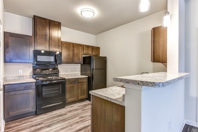 Cocina con barra de desayuno - Live Oak Apartments