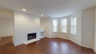 Located at 404-12 Union Blvd in St. Louis, MO, this single-floor unit offers a thoughtfully designed layout with a clean, neutral aesthetic throughout. The living room serves as the focal point of the space, showcasing rich hardwood flooring, recessed lighting, and a fireplace framed by a light stone surround with a built-in shelf alongside it. A angled bay of windows fills the corner of the living room with natural light and views of the surrounding neighborhood greenery, creating a warm and inviting atmosphere.

The kitchen is outfitted with white cabinetry extending to the ceiling for ample storage, light countertops, and a full suite of white appliances including an electric range with overhead ventilation. The bedrooms feature plush carpet flooring and are generously windowed, with one bedroom benefiting from multiple windows across two walls and another offering a closet with built-in shelving. The bathrooms are finished in classic white square tile, with one featuring a tub-shower combination with chrome fixtures and tile-surround walls. Tiled flooring completes the clean, functional look throughout the bathrooms. Overall, the unit presents a bright, well-maintained environment with consistent finishes across all rooms.