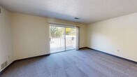 Located at 120 North Ave. in Tallmadge, Ohio, this one-bedroom, one-bathroom unit is thoughtfully laid out across a single floor, offering a practical and comfortable living arrangement. The combined living and dining area serves as the heart of the home, featuring plush blue-gray carpeting, neutral cream-toned walls with blue baseboards, and a textured ceiling. A full-width sliding glass door floods the space with natural light and opens to a private balcony overlooking mature trees, bringing the outdoors in. The kitchen is functionally designed with warm wood cabinetry, white tile backsplash, light tile flooring, and a gas range with an overhead ventilation hood, providing ample counter and storage space. A hallway connects the main living areas to the generously sized bedroom, which features carpet flooring, a large window with natural views, and its own closet with classic louvered bifold doors. In total, three closets are distributed throughout the unit, offering exceptional storage. A thermostat is conveniently located in the hallway. The bathroom and additional closet spaces round out this well-organized, move-in-ready home in the heart of Tallmadge.