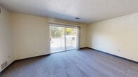 Located at 120 North Ave. in Tallmadge, Ohio, this one-bedroom, one-bathroom unit is thoughtfully laid out across a single floor, offering a practical and comfortable living arrangement. The combined living and dining area serves as the heart of the home, featuring plush blue-gray carpeting, neutral cream-toned walls with blue baseboards, and a textured ceiling. A full-width sliding glass door floods the space with natural light and opens to a private balcony overlooking mature trees, bringing the outdoors in. The kitchen is functionally designed with warm wood cabinetry, white tile backsplash, light tile flooring, and a gas range with an overhead ventilation hood, providing ample counter and storage space. A hallway connects the main living areas to the generously sized bedroom, which features carpet flooring, a large window with natural views, and its own closet with classic louvered bifold doors. In total, three closets are distributed throughout the unit, offering exceptional storage. A thermostat is conveniently located in the hallway. The bathroom and additional closet spaces round out this well-organized, move-in-ready home in the heart of Tallmadge.
