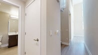 Located in the heart of Downtown Los Angeles, this two-story, two-bedroom, two-bathroom residence offers a well-designed layout spread across two floors. The main level serves as the primary living area, featuring a modern kitchen outfitted with dark wood cabinetry, light quartz countertops, a white tile backsplash, and a full suite of stainless steel appliances including a gas range, built-in microwave, dishwasher, and refrigerator. Soaring ceilings in the kitchen and adjacent areas allow natural light to pour in through large windows, creating a bright and open atmosphere. Light-toned hardwood-style flooring flows throughout the main level, complementing the clean, neutral palette of the space. The upper level houses the bedrooms, each carpeted for comfort and fitted with windows dressed in horizontal blinds. The primary bedroom includes access to a dedicated closet, while the second bedroom also benefits from its own closet space. Both bathrooms feature wood-style flooring, neutral tones, and clean fixtures. Additional highlights include dedicated hallways, ample closet storage on both levels, and a spiral staircase connecting the two floors, adding an architectural focal point to the interior.