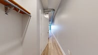 Located at 770 N Grant St in Denver, CO, this one-bedroom, one-bathroom unit offers a thoughtfully designed layout with modern finishes throughout. Light wood-tone flooring flows consistently across every room, complementing the neutral gray walls and crisp white trim that define the interior palette. Exposed silver ductwork runs along the ceilings, lending an industrial character to the space.

The open-concept kitchen and living area serves as the heart of the unit. The kitchen is outfitted with bold blue cabinetry, stainless steel appliances including a refrigerator, range, and microwave, a mosaic tile backsplash, and a peninsula with a matching blue front that doubles as a breakfast bar. The adjacent living area features tall windows that usher in natural light and views of the surrounding neighborhood.

The bedroom is a comfortable, well-proportioned room with mirrored sliding closet doors that enhance the sense of space, plus an additional walk-in closet area. A long hallway connects the main living spaces to the private quarters, with a coat closet at the entry.

The bathroom is cleanly appointed with a combination tub and shower, a modern vanity with mirrored medicine cabinet, mosaic tile backsplash accents, and wood-tone flooring that maintains visual continuity with the rest of the unit.