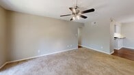 Located at 19 Landmark Dr in Columbia, SC, this single-story home offers a well-organized layout with four bedrooms, two bathrooms, and a generous living room. The floor plan makes efficient use of space throughout, connecting rooms via two hallways for easy navigation.

The living room is a comfortable gathering area featuring plush wall-to-wall carpeting, a ceiling fan with light fixture, and a sliding glass door that opens to a private balcony with outdoor views — filling the room with natural light.

Each of the four bedrooms continues the carpeted flooring theme and is equipped with ceiling fans. The bedrooms are finished in neutral, warm-toned walls that create a calm and versatile backdrop. Several bedrooms feature windows with blinds that allow natural light while maintaining privacy. The primary bedroom includes a built-in closet for convenient storage.

The two bathrooms are clean and functional. One features warm hardwood flooring and a tub-shower combination with a curved curtain rod, while the other includes a crisp white tub-shower surround with chrome fixtures and a built-in niche. Both bathrooms are finished in bright white tones for a fresh, clean feel.

The central areas of the home feature hardwood-style flooring, providing a pleasant contrast to the carpeted living and sleeping areas. Overall, this home presents a practical and comfortable living environment in Columbia, SC.