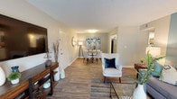 This single-story residence at The Harper offers a thoughtfully designed layout that balances open communal spaces with comfortable private quarters. The living room serves as the heart of the home, featuring wood-style plank flooring, a textured ceiling, and a striking teal accent wall that anchors the space. French doors open to a private balcony, filling the room with natural light and outdoor views. The adjoining dining area flows seamlessly from the living room and is illuminated by a contemporary flush-mount fixture, with direct sightlines to the kitchen for easy entertaining.

The kitchen is outfitted with white shaker cabinetry, granite countertops, a subway tile backsplash, and stainless steel GE appliances including a range, microwave, and dishwasher. The bedrooms are carpeted for comfort and feature ceiling fans, natural light from windows, and generous closet storage. At least one bedroom includes a spacious walk-in-style closet area alongside in-unit washer/dryer connections. The bathroom features a granite-topped vanity, wood-style flooring, and a tub-shower combination with large-format marble-style tile surround.