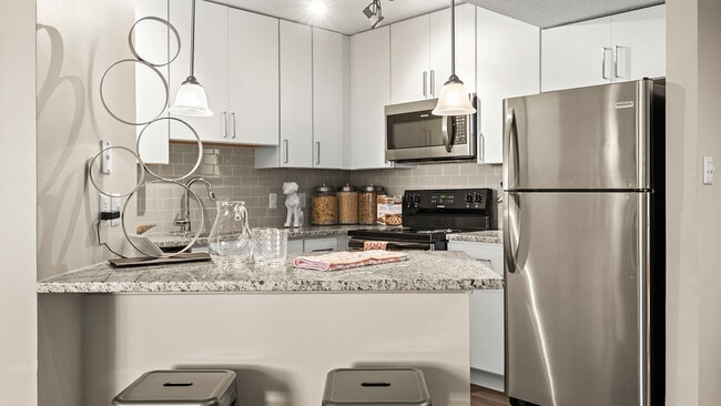 Cocina moderna con acabados elegantes y electrodomésticos de acero inoxidable. - Buckhead and Vine