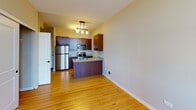 Located at 134 Fifth St E in downtown Saint Paul, Minnesota, this single-floor unit offers a well-designed layout with consistent bamboo hardwood flooring throughout, lending warmth and a cohesive aesthetic to the entire space.

The kitchen serves as a functional centerpiece, featuring rich dark-wood cabinetry, granite countertops, and a full suite of stainless steel appliances including a refrigerator, electric range, and built-in microwave. A peninsula with an integrated stainless steel sink provides additional prep space and separates the kitchen from the open living area. A built-in wine rack adds a refined touch to the upper cabinetry.

The living area is bright and open, benefiting from multiple wood-framed windows that frame views of the surrounding downtown Saint Paul skyline, allowing natural light to fill the space throughout the day.

The bathroom is thoughtfully combined with an in-unit laundry area, housing a stacked Bosch washer and dryer alongside a tiled tub-shower combination with a rain showerhead, a toilet, and a vanity with granite countertop. The bamboo flooring extends into this space, maintaining design continuity.

Overall, the unit presents a clean, modern aesthetic with quality finishes throughout, situated conveniently in the heart of downtown Saint Paul.