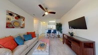 Located at 111 Coopers Ridge Blvd in Ladson, South Carolina, this single-floor residence offers a thoughtfully designed layout with a welcoming ambiance throughout. The living area is carpeted and generously sized, featuring a ceiling fan, large French doors that fill the space with natural light, and an open sightline to the kitchen — creating a seamless flow between everyday living and dining. A breakfast bar with bar seating connects the living room to the kitchen, which is outfitted with white cabinetry, full appliances including a range, microwave, refrigerator, and dishwasher, all set on easy-to-maintain tile flooring. The bedroom is a comfortable retreat with plush carpeting, natural light from a window, and ample space. The bathrooms are clean and functional, with tile flooring, a vanity with storage, and a tub-shower combination. A private balcony extends the living space outdoors, framed by lush, mature trees and blooming landscaping that offer a serene natural backdrop. The community also features an impressive clubhouse-style common area with soaring ceilings, a tray ceiling accent, a fireplace, built-in bookshelves, and abundant natural light — ideal for socializing or relaxing.