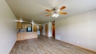 Located at 201 Southridge Rd in Tahlequah, Oklahoma, this single-story 2-bedroom, 2-bathroom home offers a well-organized layout with consistent light-toned luxury vinyl plank flooring and warm wood-toned baseboards throughout. The open living room is generously sized, featuring a ceiling fan with light kit, a textured ceiling, and a window that lets in natural light with views of the surrounding greenery. The kitchen is thoughtfully designed with a wraparound peninsula offering additional counter space, light oak cabinetry providing ample storage, laminate countertops, a double-basin sink, and black appliances including a range, microwave, refrigerator, and dishwasher. A laundry area is also accessible from the kitchen. Both bedrooms are comfortably sized, each equipped with ceiling fans and closets. The primary bedroom features a window overlooking the outdoors and offers generous proportions. The second bedroom includes a double-door closet and an adjacent door for added convenience. The two bathrooms are functionally appointed, each featuring a tub/shower combination, overhead cabinetry, wood-look flooring, and neutral wall tones that contribute to a clean, cohesive aesthetic throughout the home.