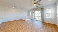 Located at 9975 W Encanto Blvd in Avondale, Arizona, this two-story, three-bedroom, two-bathroom home offers a clean, modern aesthetic throughout. The ground floor houses an attached garage with an automatic opener, recessed lighting, and interior access — providing ample space for vehicles and storage. The main living level features an open-concept kitchen and living room anchored by light wood-look flooring that runs throughout the home. The kitchen is outfitted with white shaker-style cabinetry, a large peninsula with a white quartz countertop, stainless steel appliances including a refrigerator, range, and microwave, and recessed lighting. A ceiling fan and sliding glass door open the living area to a private balcony with neighborhood views. The three bedrooms are bright and well-proportioned, each featuring ceiling fans, natural light from well-placed windows, and wood-look flooring. The primary bedroom includes an en-suite bathroom with a walk-in shower, white vanity cabinetry, and quartz countertops. The secondary bathroom offers a full tub-shower combo with subway tile surround, a white vanity, and a window for natural light. The home's clean white walls and consistent modern finishes create a cohesive, move-in-ready atmosphere throughout.