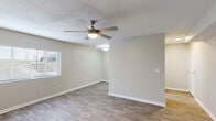 Located in Augusta, GA, this well-appointed 2-bedroom, 1-bathroom home offers a clean, modern aesthetic across its single-level floor plan. Wood-look flooring runs throughout the entire space, creating a cohesive and easy-to-maintain foundation in every room.

The kitchen is a standout feature, designed in a galley style with white shaker cabinets, light granite countertops, classic white subway tile backsplash, and stainless steel appliances including a refrigerator and electric range. Ample cabinet storage and counter space make it both functional and visually appealing.

The living area is bright and open, featuring a textured ceiling, ceiling fan with light fixture, and a window that brings in natural light. Neutral warm-gray walls complement the flooring and create a welcoming atmosphere throughout.

Both bedrooms are comfortably sized, each equipped with a ceiling fan, and benefit from natural light through windows with blinds. The primary bedroom includes closet access via a classic six-panel door. The bathroom features a white vanity with granite countertop and brushed nickel fixtures, maintaining the consistent modern finish seen across the home.

A hallway connects the bedrooms and bathroom, reinforcing the efficient and practical layout of this Augusta residence.